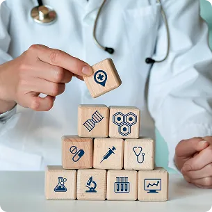 Hands stacking building blocks with medical icons