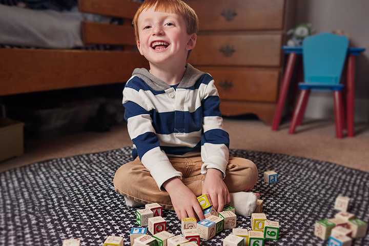 Emmet sitting on the floor playing with blocks