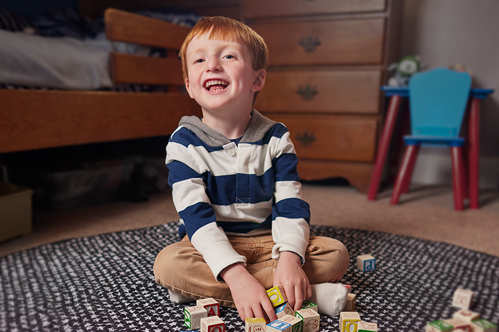 Emmet sitting on the floor playing with blocks