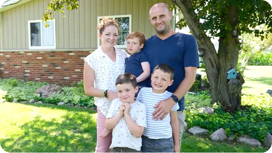 Emmett and his family outside their home