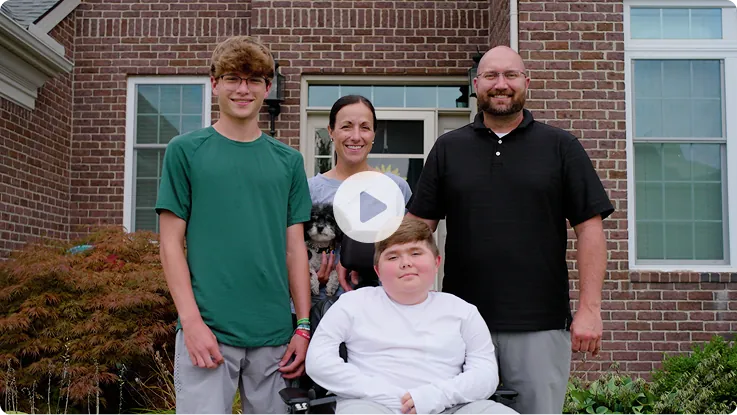 Video thumbnail: Nathan and his family standing together outside their home. Watch Nathan's story.