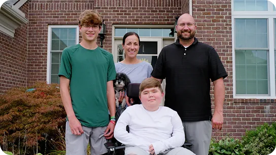 Nathan and his family outside their home