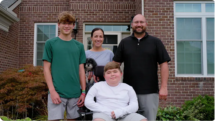 Nathan and his family outside their home